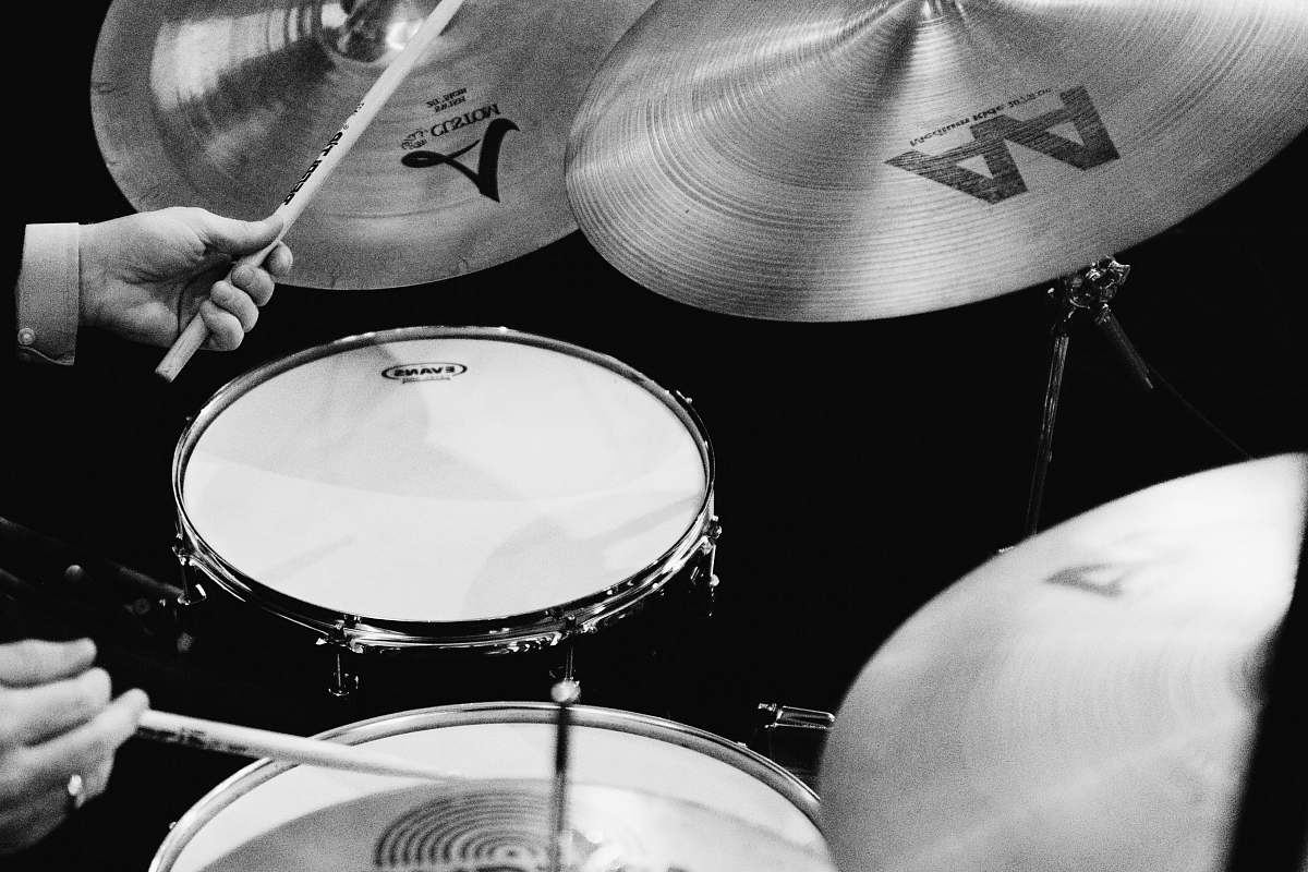 musical instrument grayscale photography of man playing drums percussion